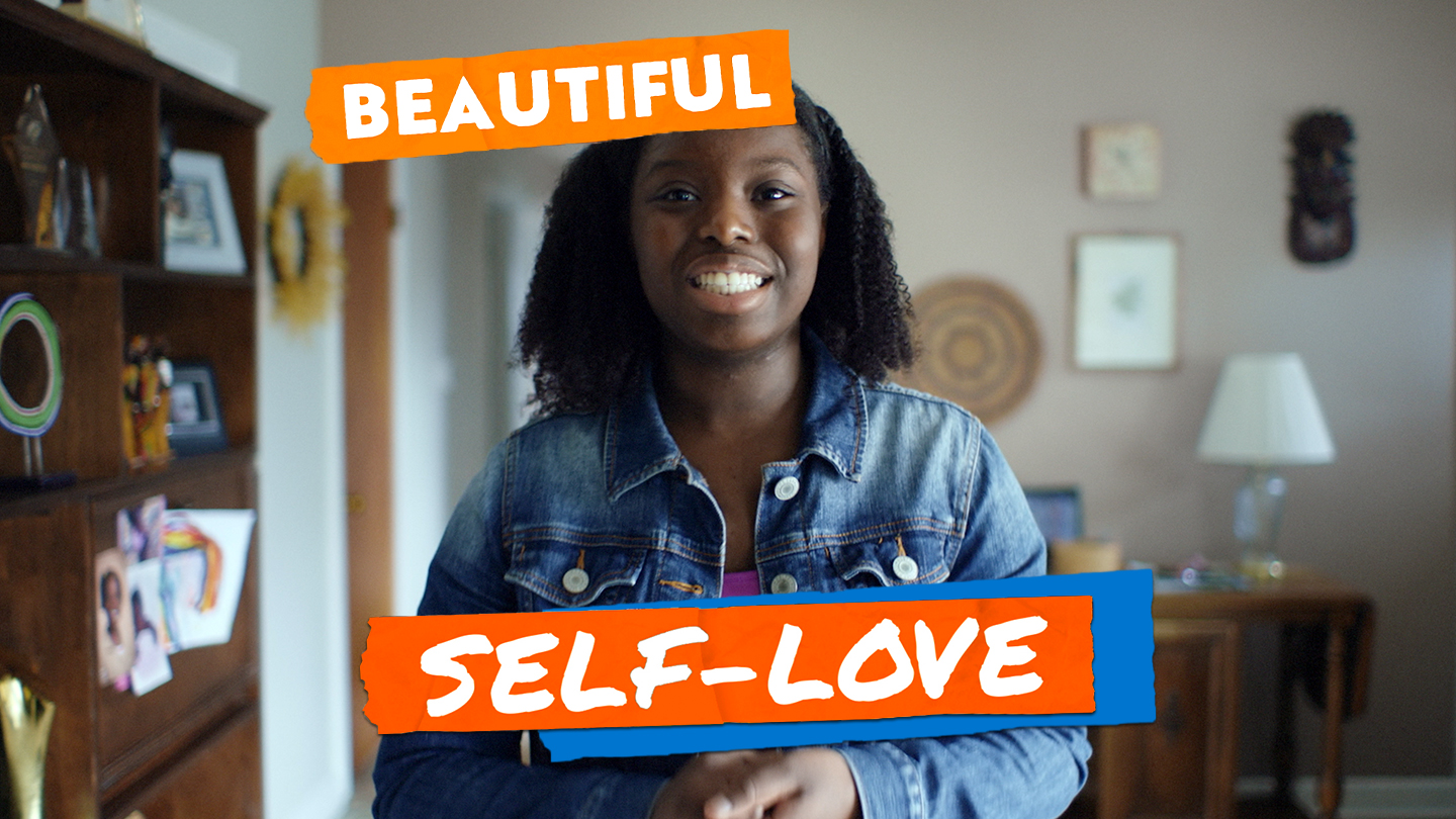 Title: Beautiful Self-Love. A young African-American woman in a jean jacket smiles for the Vision Board of America.