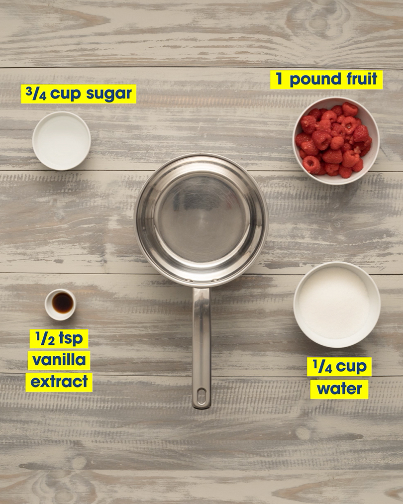 An empty saucepan, seen from above. Around it in variously sized white bowls are 3/4 cup of sugar, 1/2 teaspoon vanilla extract, 1 pound of raspberries, and 1/4 cup of water.